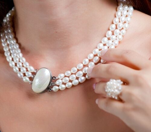 A woman wearing a pearl necklace, which is not suitable for vegans