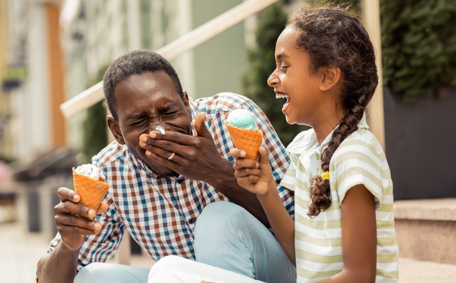 A dad and daughter enjoying vegan ice cream in the sun