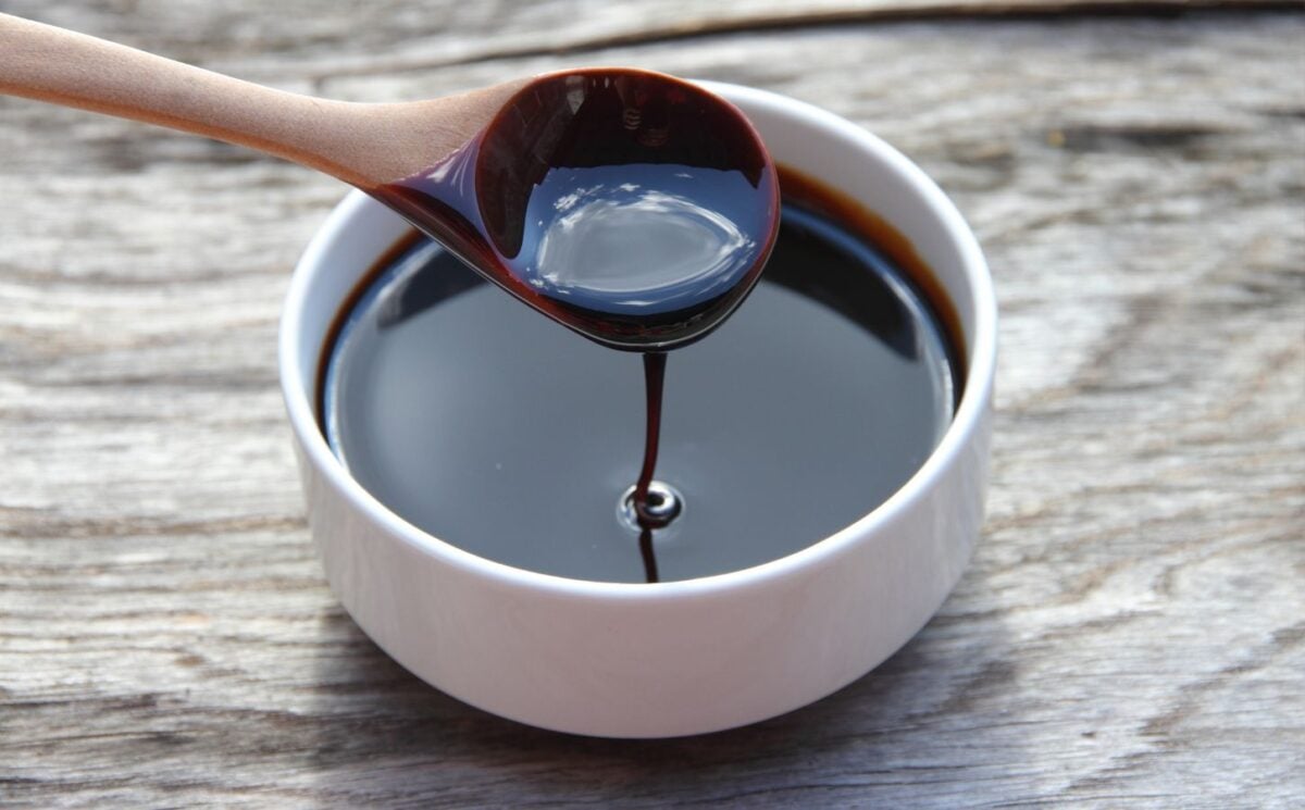 A bowl and spoon full of blackstrap molasses, an iron-rich vegan food