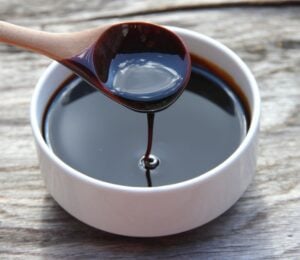 A bowl and spoon full of blackstrap molasses, an iron-rich vegan food