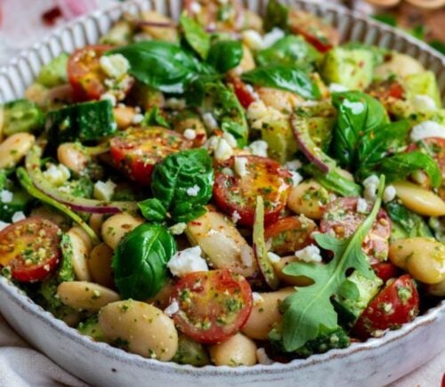 A butter beans salad recipe featuring tomatoes, spinach, and vegan cheese