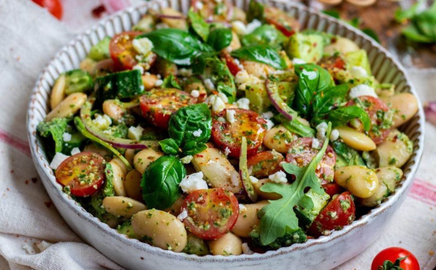 A butter beans salad recipe featuring tomatoes, spinach, and vegan cheese