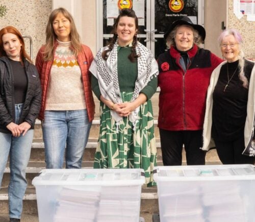 Photo shows five CEFF volunteers standing with large boxes of signatures before handing them in