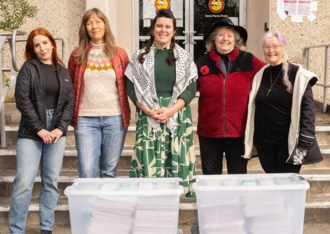 Photo shows five CEFF volunteers standing with large boxes of signatures before handing them in