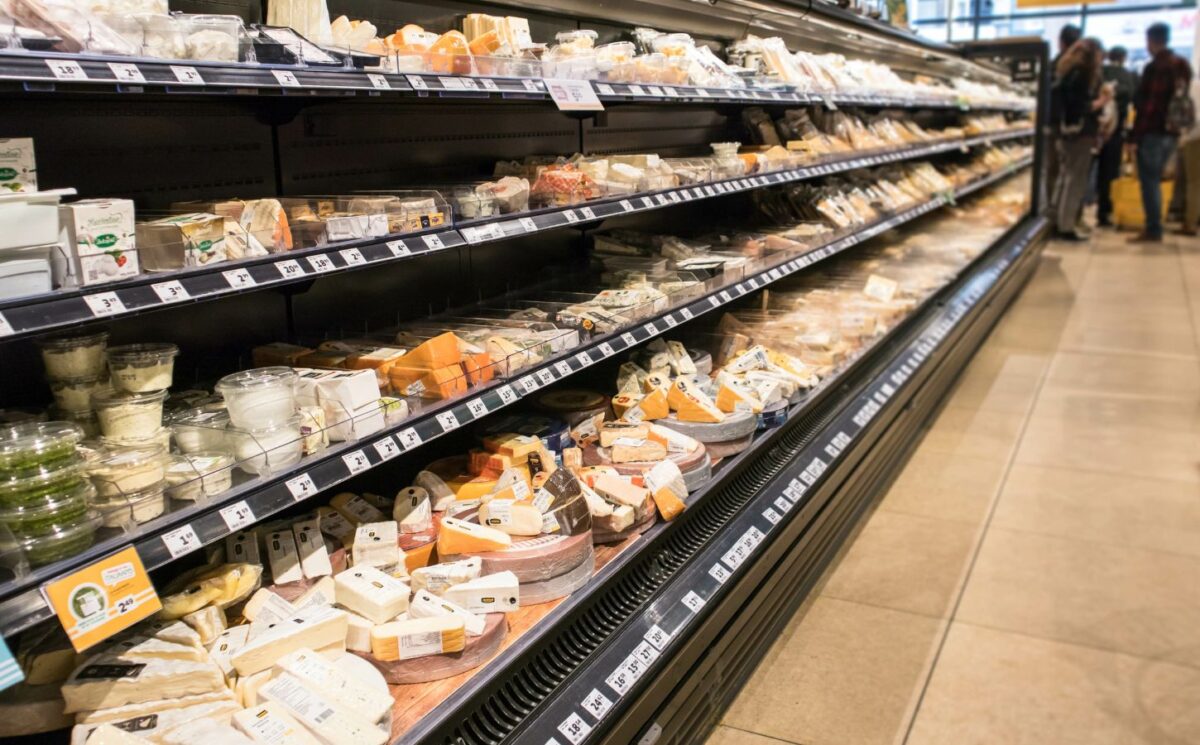 Photo shows the dairy aisle of a supermarket complete with several different varieties of cheese