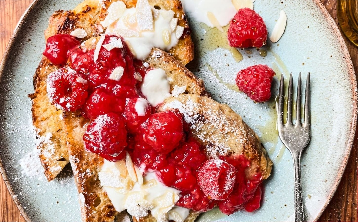 A plate of vegan french toast covered in fruit and syrup