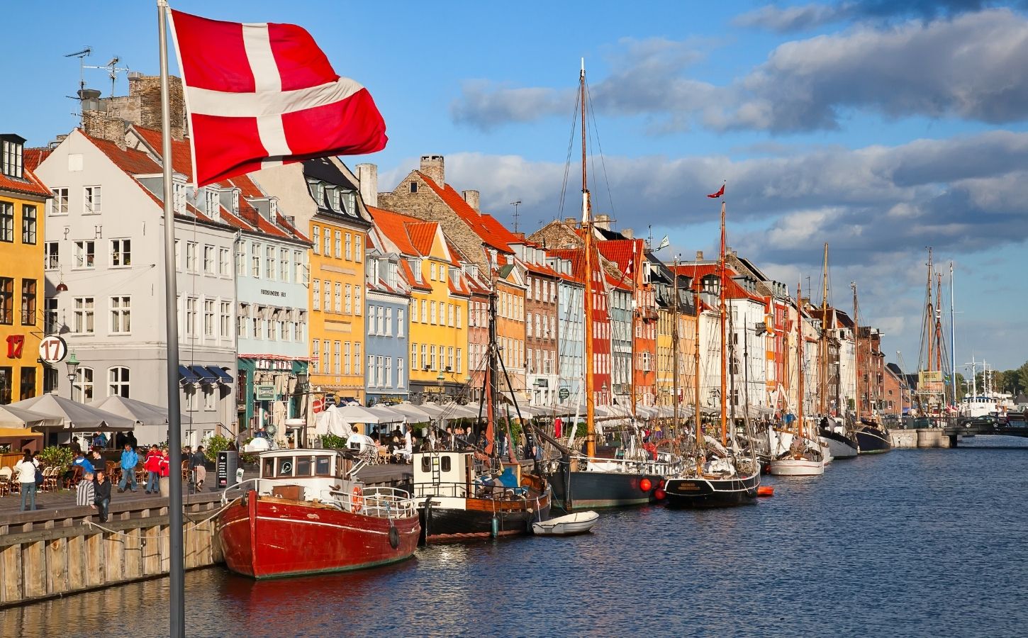 A shot of Denmark, which has just introduced a plant-based roadmap, on a sunny day with colorful buildings and the Danish flag