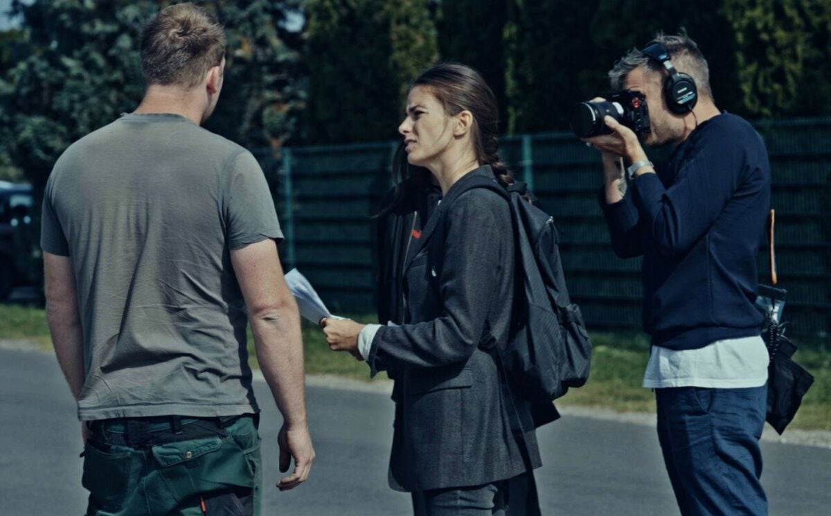 A still from new vegan documentary Food For Proft, showing a woman interviewing a man while another man holds a camera