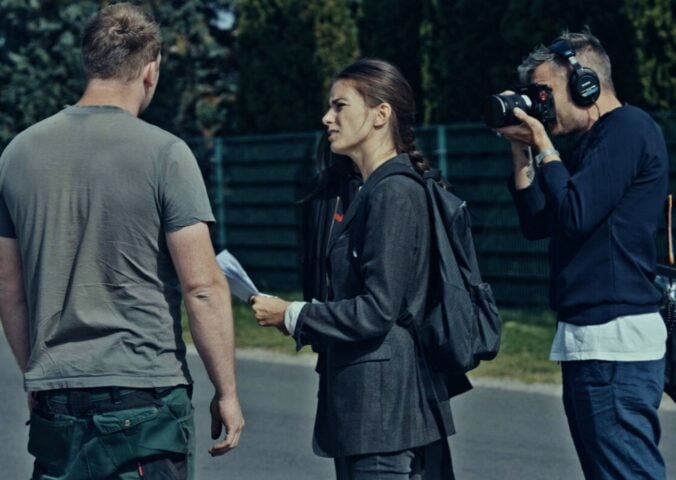 A still from new vegan documentary Food For Proft, showing a woman interviewing a man while another man holds a camera