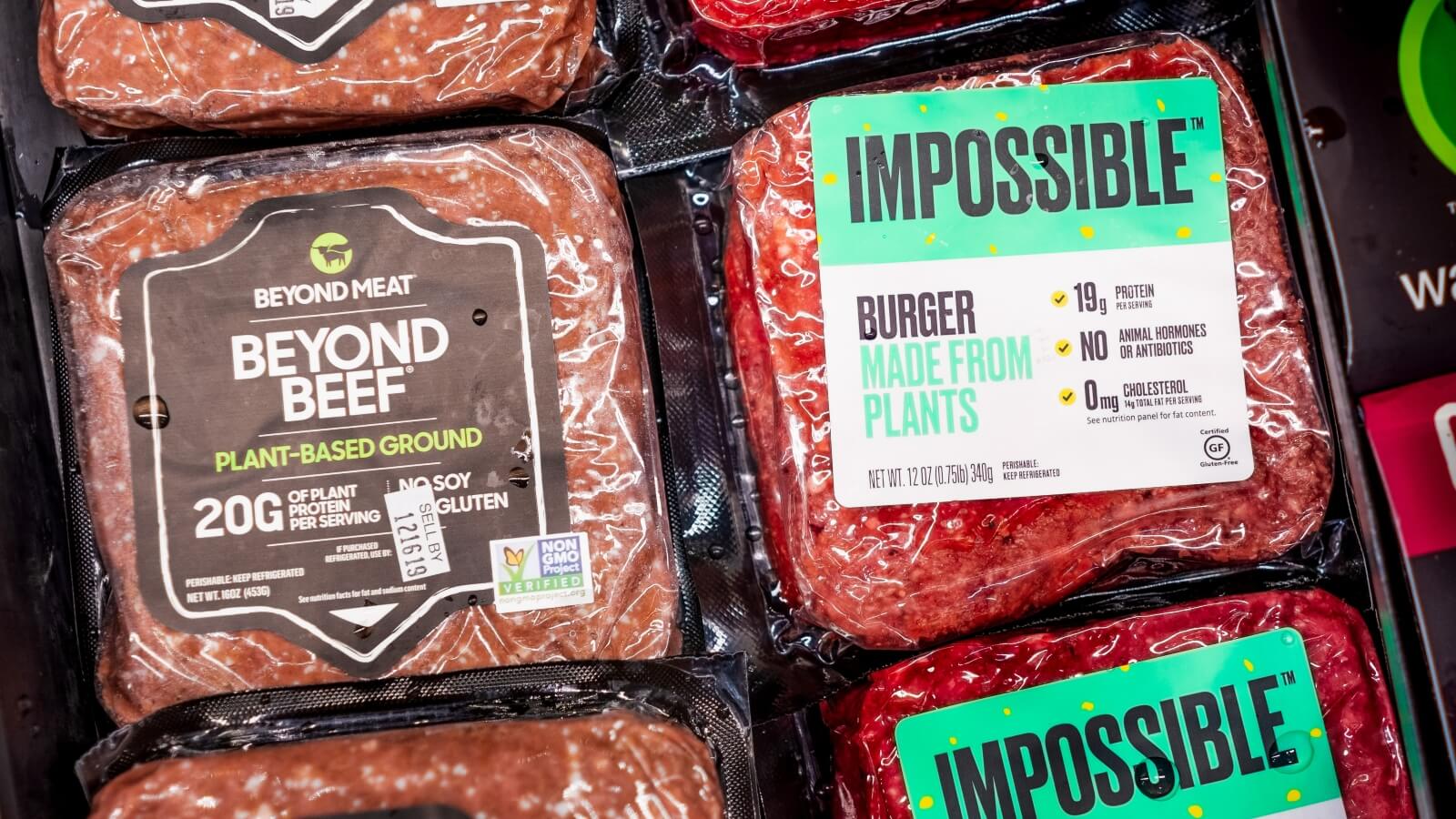 A packet of Beyond Beef beside Impossible Foods' meat