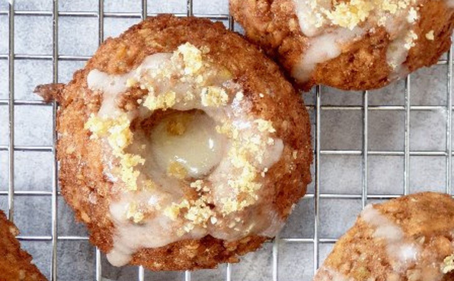 Small vegan nut-free carrot cakes with lemon drizzle and hemp heart praline cookies in a bundt tin and shot on a cooling rack