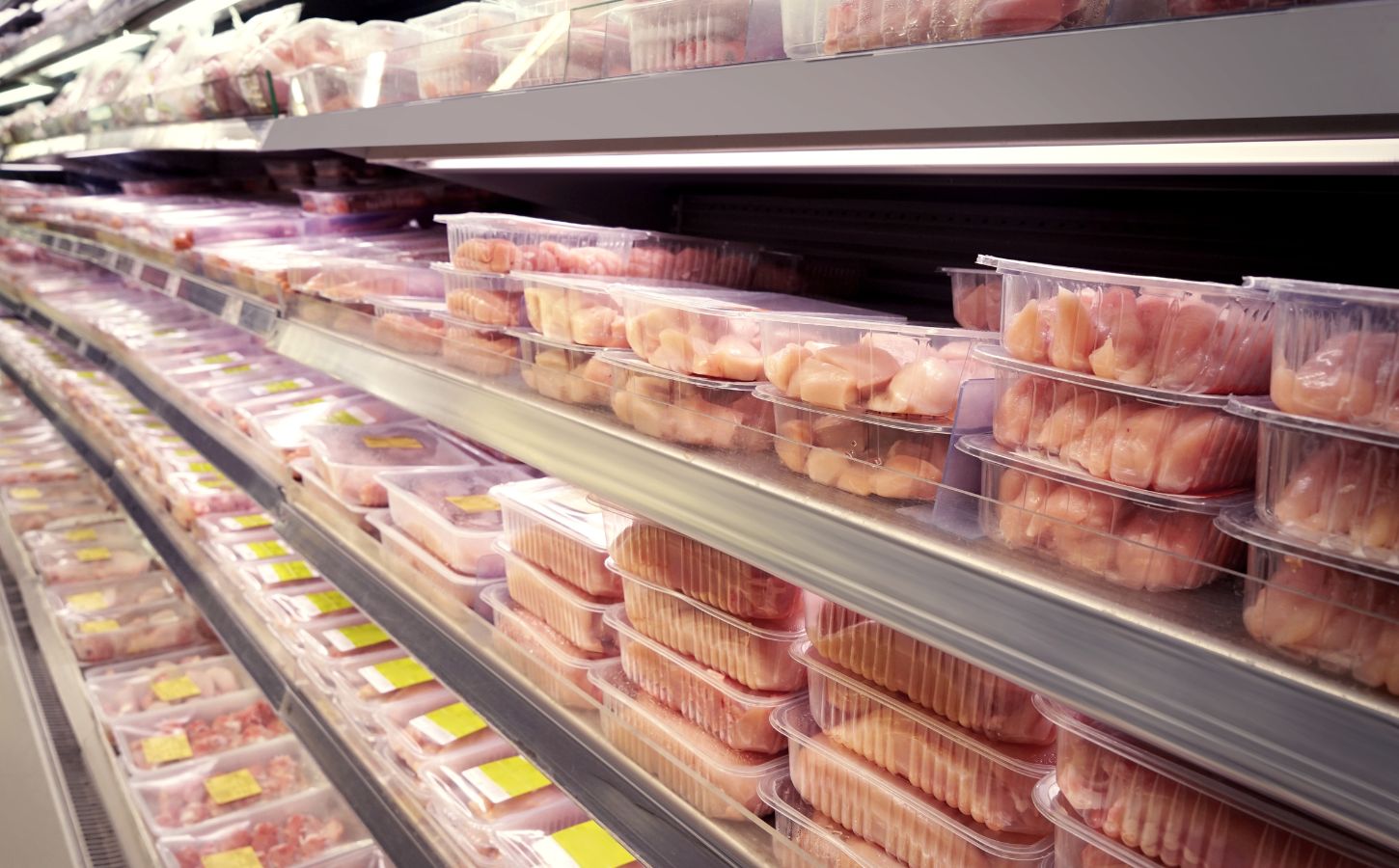 Photo of packaged raw meat products on supermarket shelves.