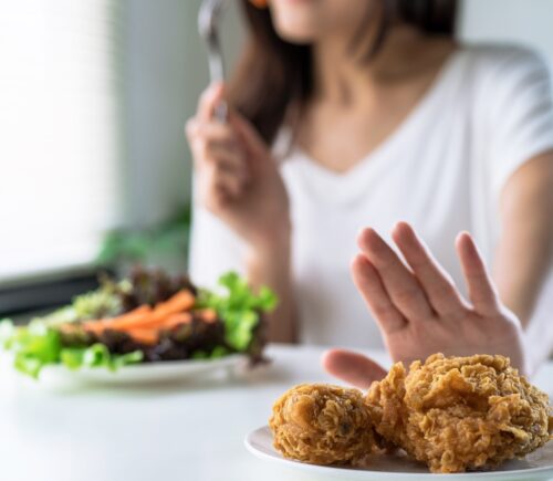 Person pushing meat away to eat vegan food