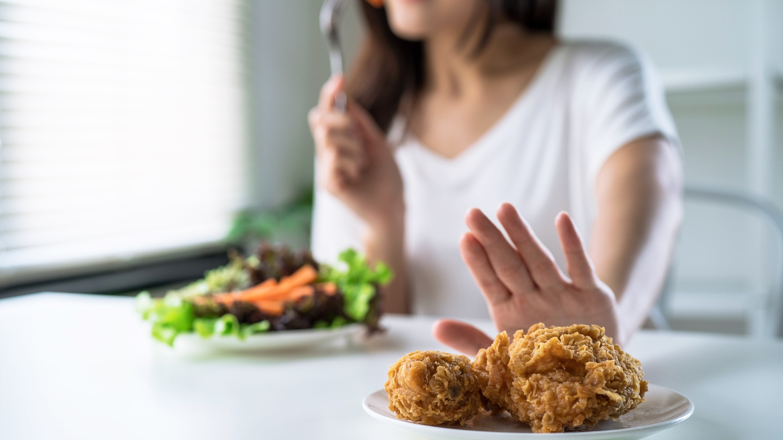 Person pushing meat away to eat vegan food