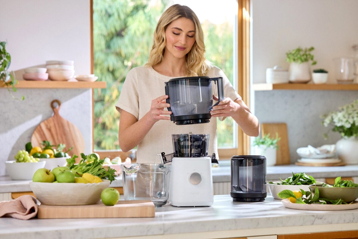 A woman making juice with a NAMA juicer