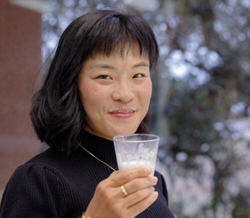 TurtleTree CEO and Co-Founder Fengru Lin holds a glass of the world's first vegan-certified lactoferrin, LF+