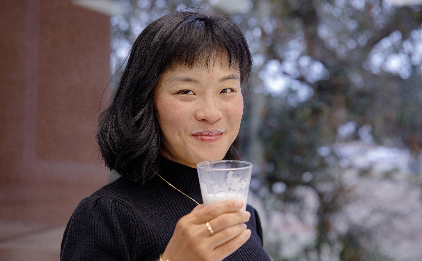 TurtleTree CEO and Co-Founder Fengru Lin holds a glass of the world's first vegan-certified lactoferrin, LF+