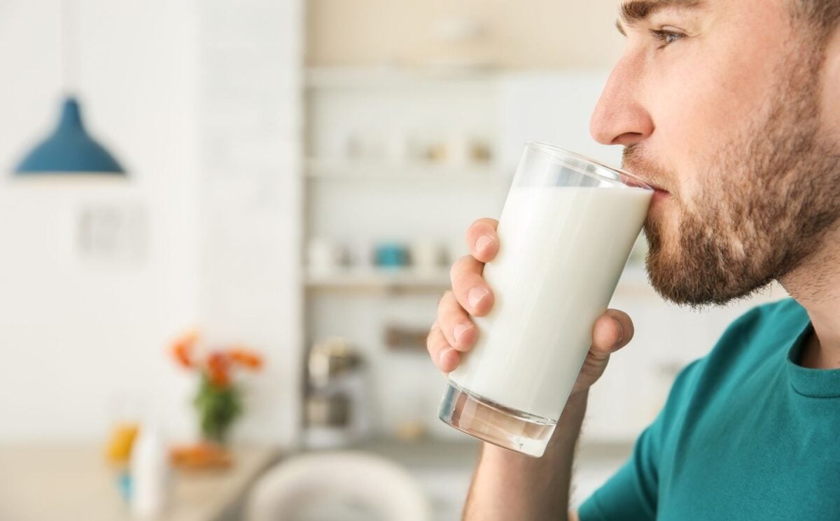 A man drinking raw milk in a kitchen