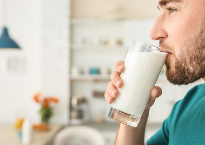 A man drinking raw milk in a kitchen