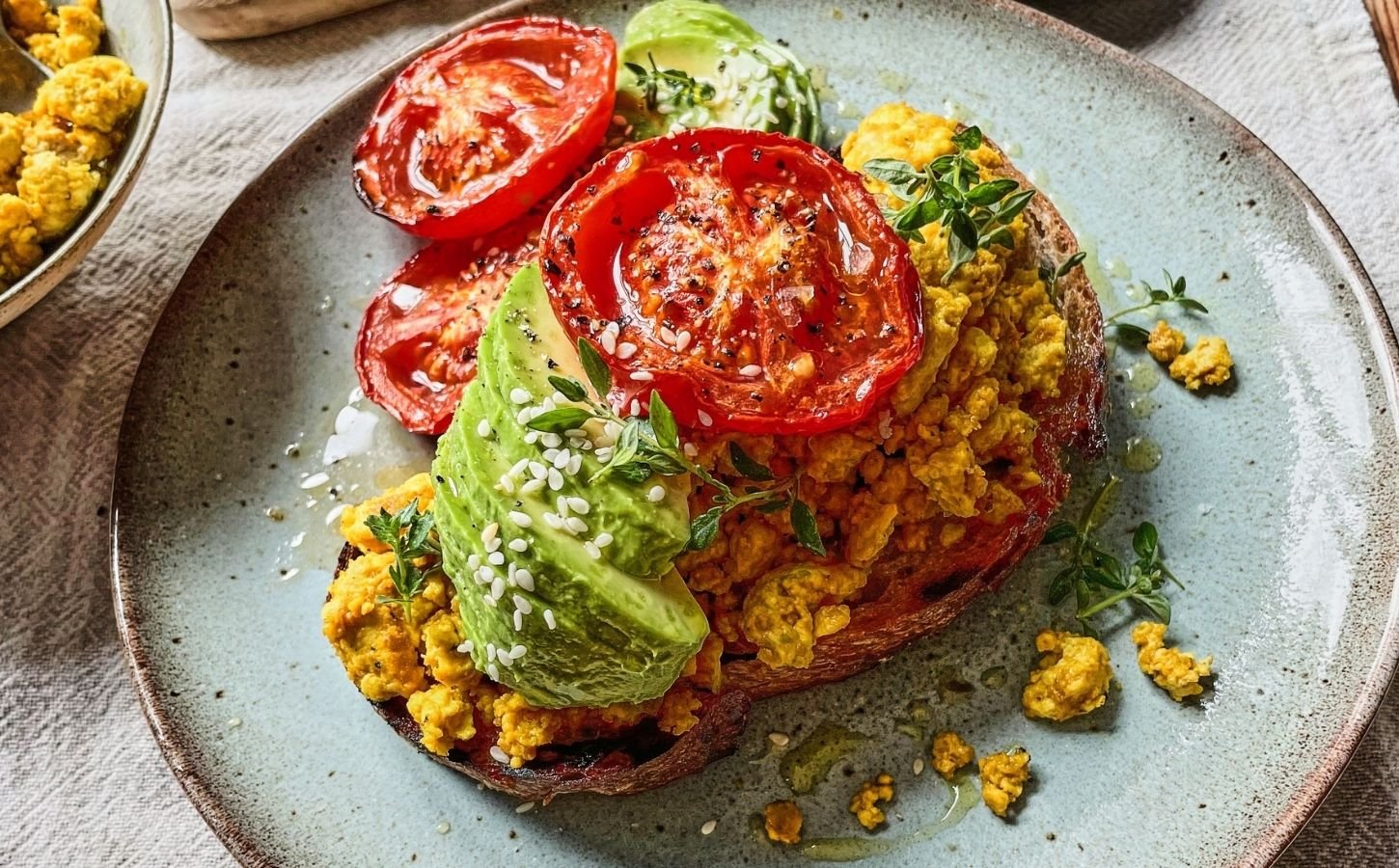 Vegan scrambled tofu served with egg, tomato, and avocado