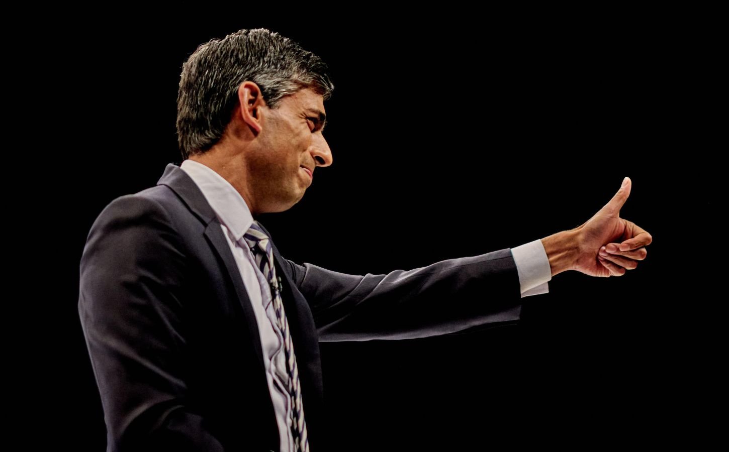 UK Prime Minister Rishi Sunak giving a thumbs up while addressing a crowd