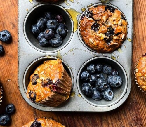 A tray of freshly cooked vegan breakfast muffins with blueberries