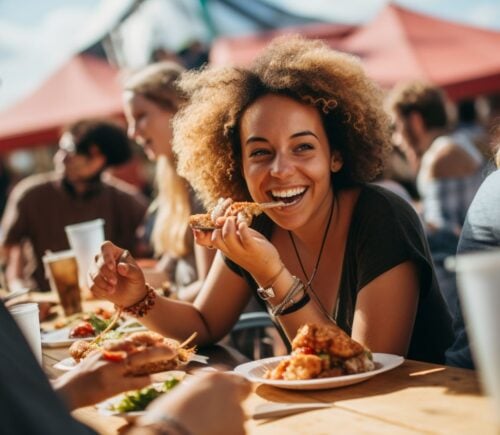 An AI-generated image of a woman eating vegan food at a festival