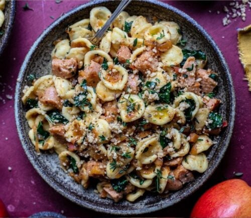 Photo shows a large bowl of sausage and kale pasta prepared using a vegan comfort food recipe.