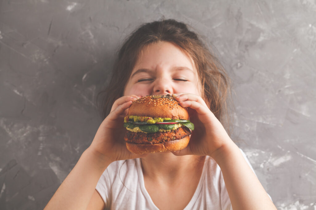 A child eating a healthy vegan burger