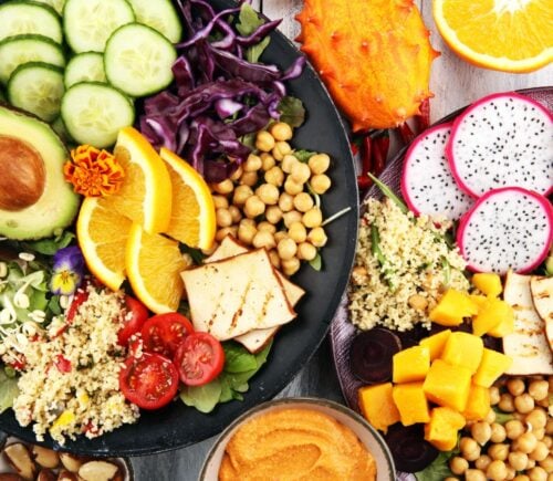 A spread of plant foods including cucumber, avocado and chickpeas, which can be part of a healthy vegan diet