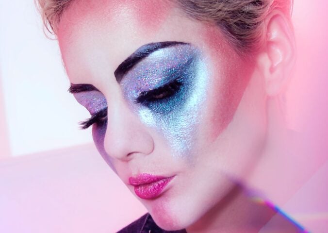 Close up shot of a woman wearing lots of brightly colored eye shadow