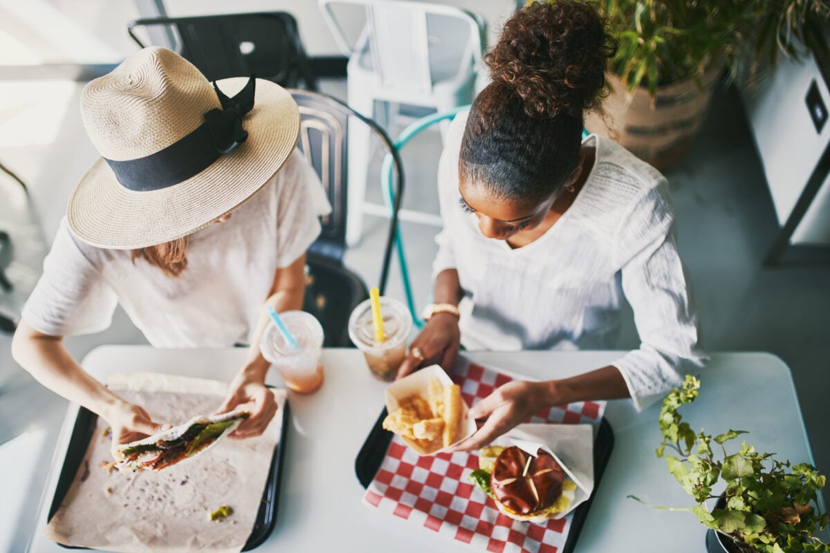 Two friends eating vegan food at a fast food restaurant