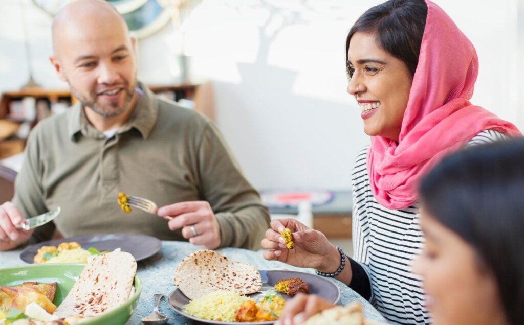 A family sit around a dinner table eating plant-based food