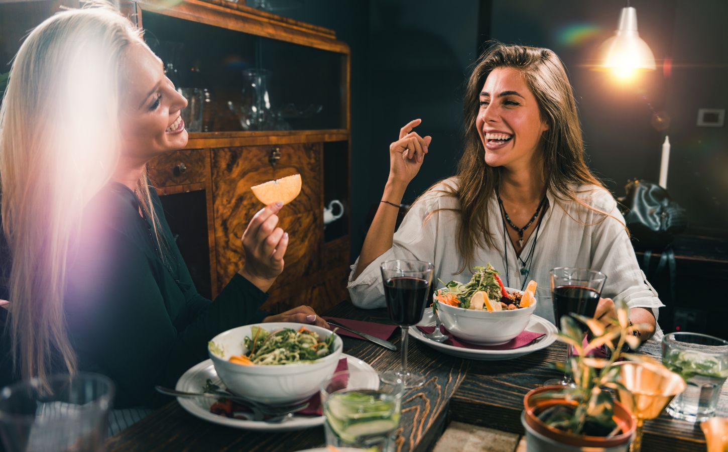 Two smiling women enjoy a vegan meal during Veganuary