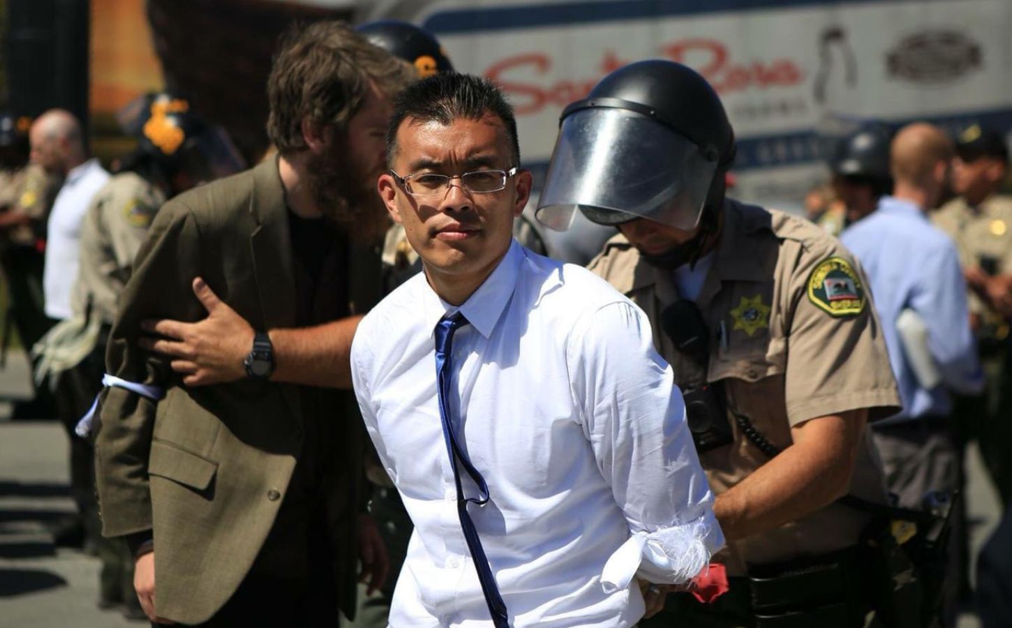 Direct Action Everywhere animal activist Wayne Hsiung being held in handcuffs by police