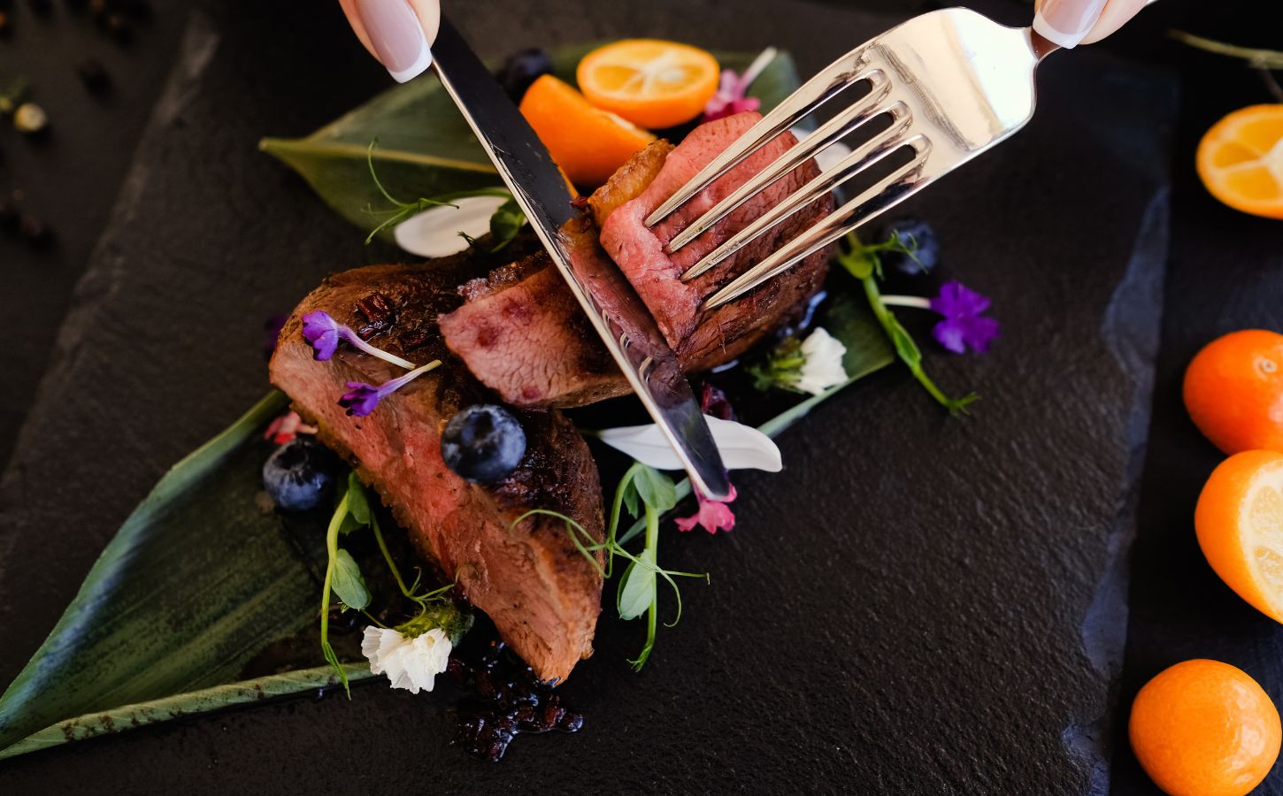 a person cutting a meat steak