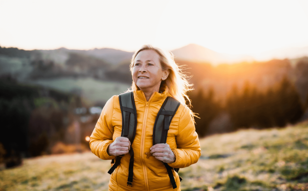 A woman wearing a backpack exploring nature outdoors